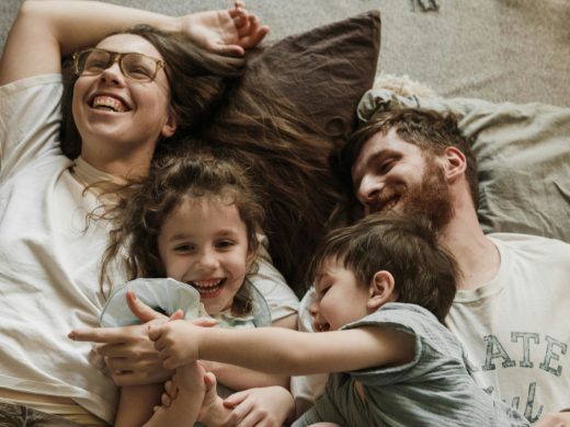 Мама, папа и двое детей лежат на кровати