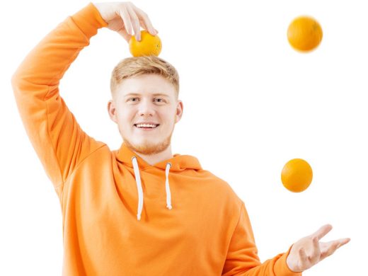 молодой человек жонглирует апельсинами