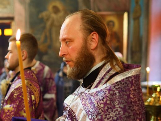 Священник держит свечу